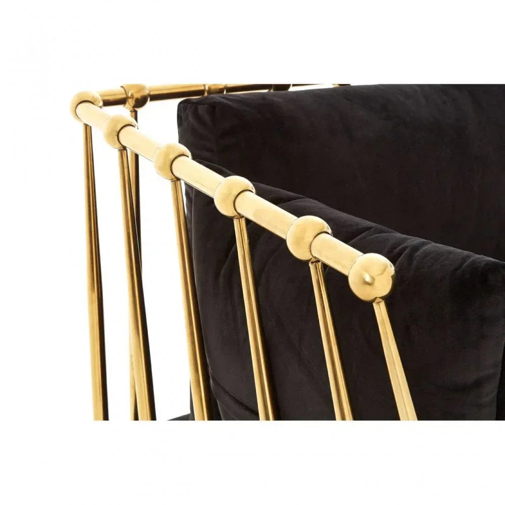 Black velvet sofa with gold metal armrest frame, close-up on modern furniture detailing