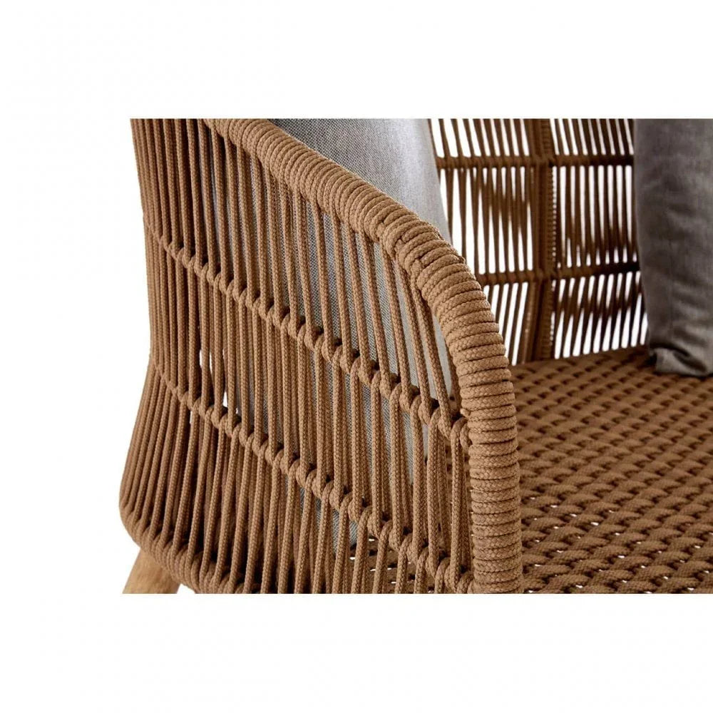 Closeup of brown rattan armchair with woven rope design and grey cushion