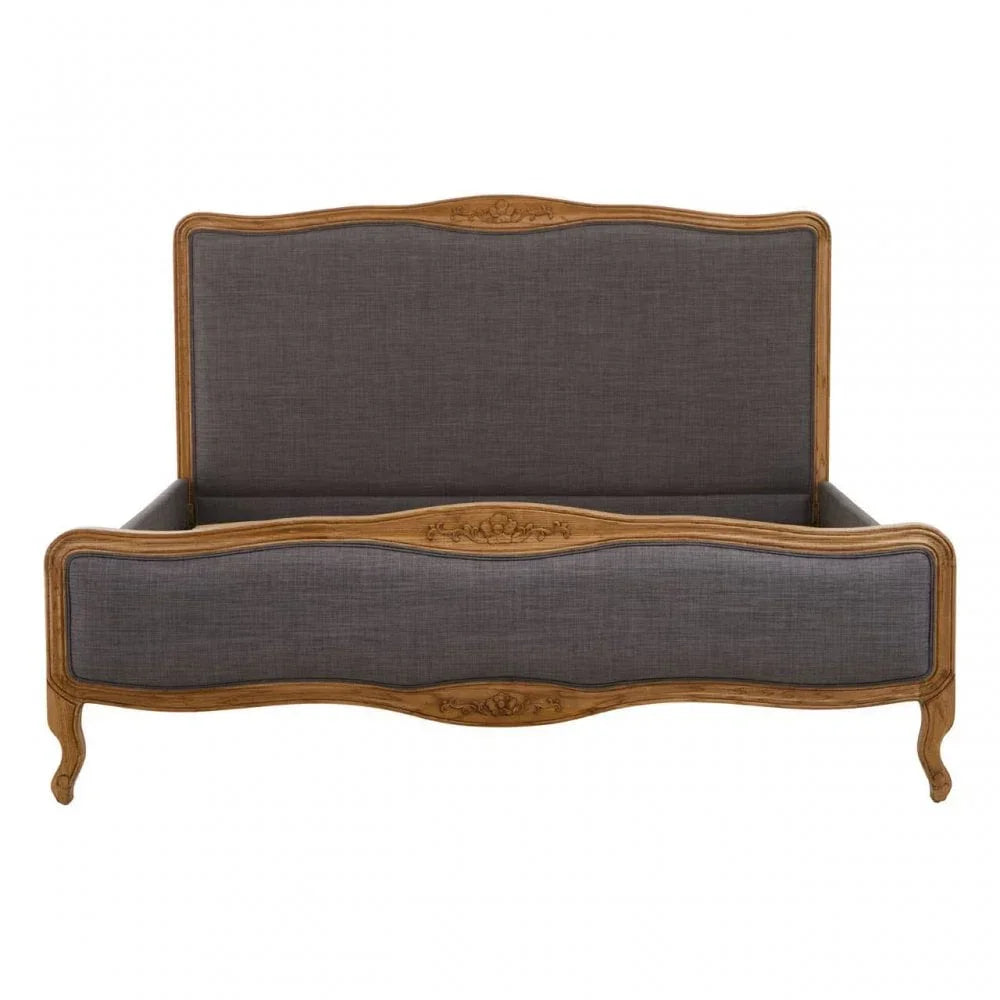 Upholstered wooden bed frame with carved detailing and grey fabric panels, front view