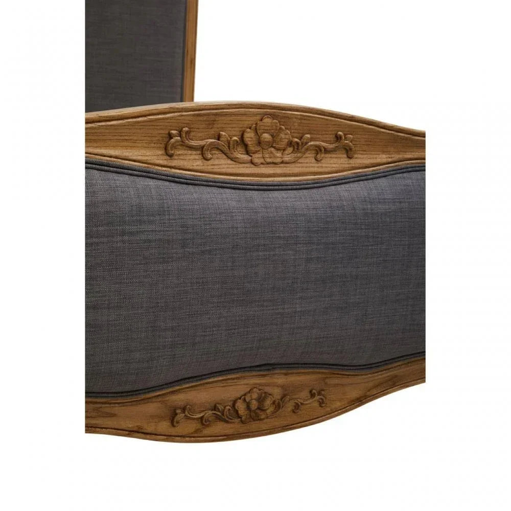 Carved oak bed frame with floral detail and dark grey upholstered panel