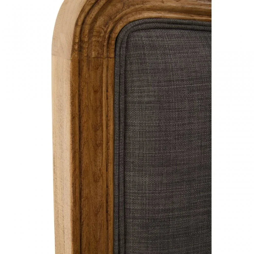 Closeup of wooden bed frame with dark grey upholstered headboard panel
