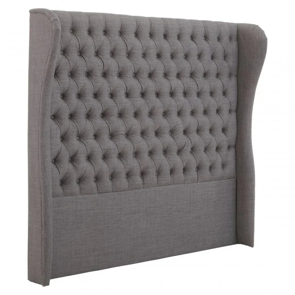 Grey fabric wingback headboard with deep button tufting, angled front view