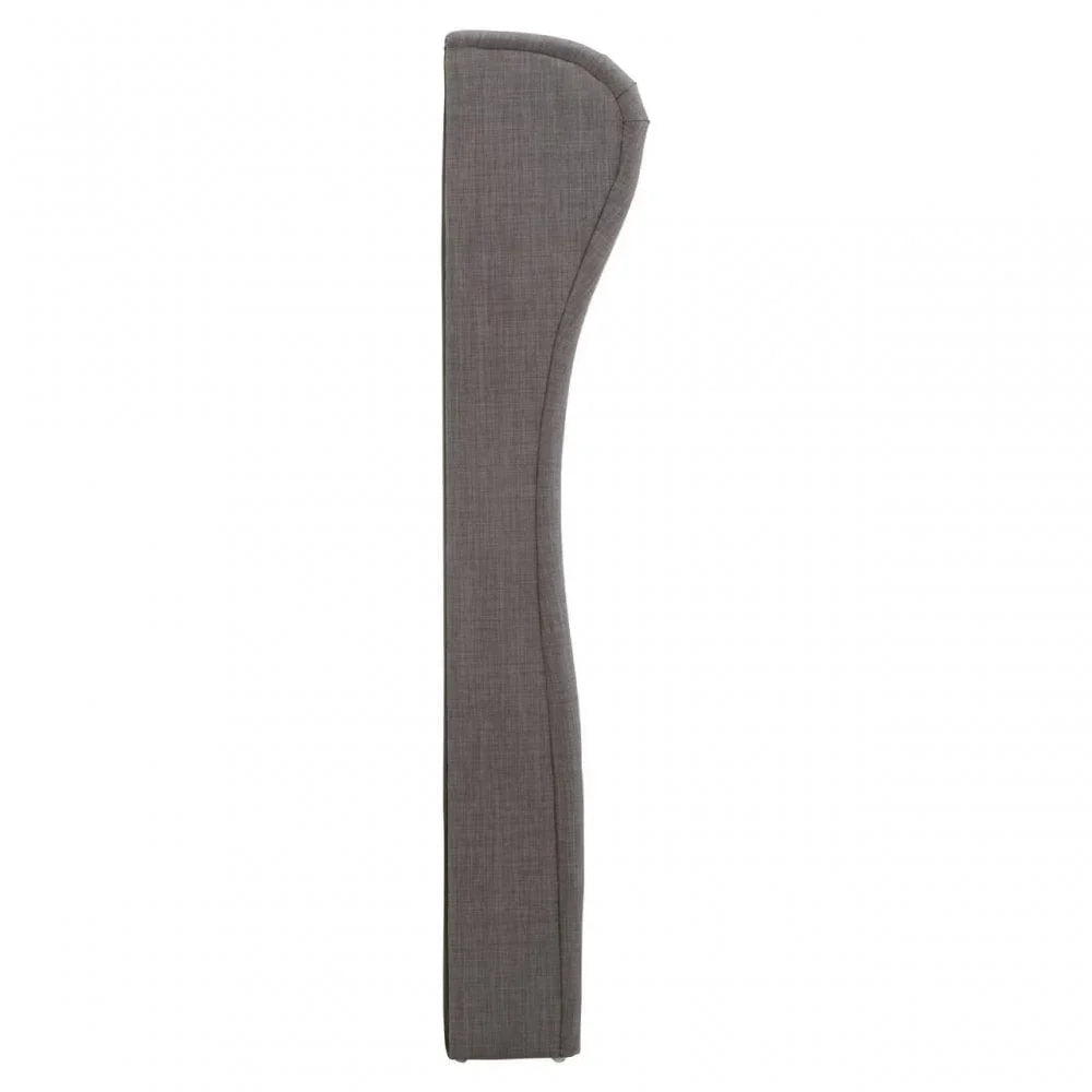 Side profile of grey fabric headboard with curved design