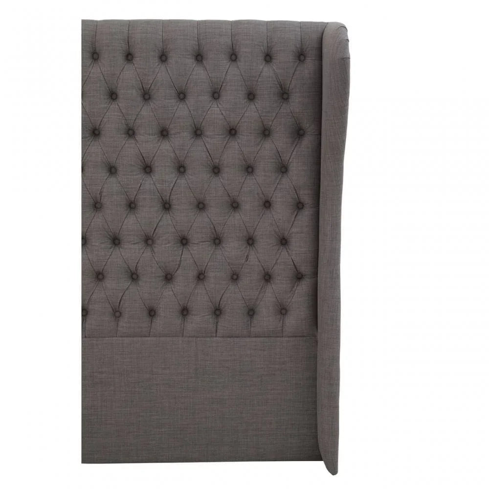 Grey fabric upholstered headboard with deep button tufting and winged side detail