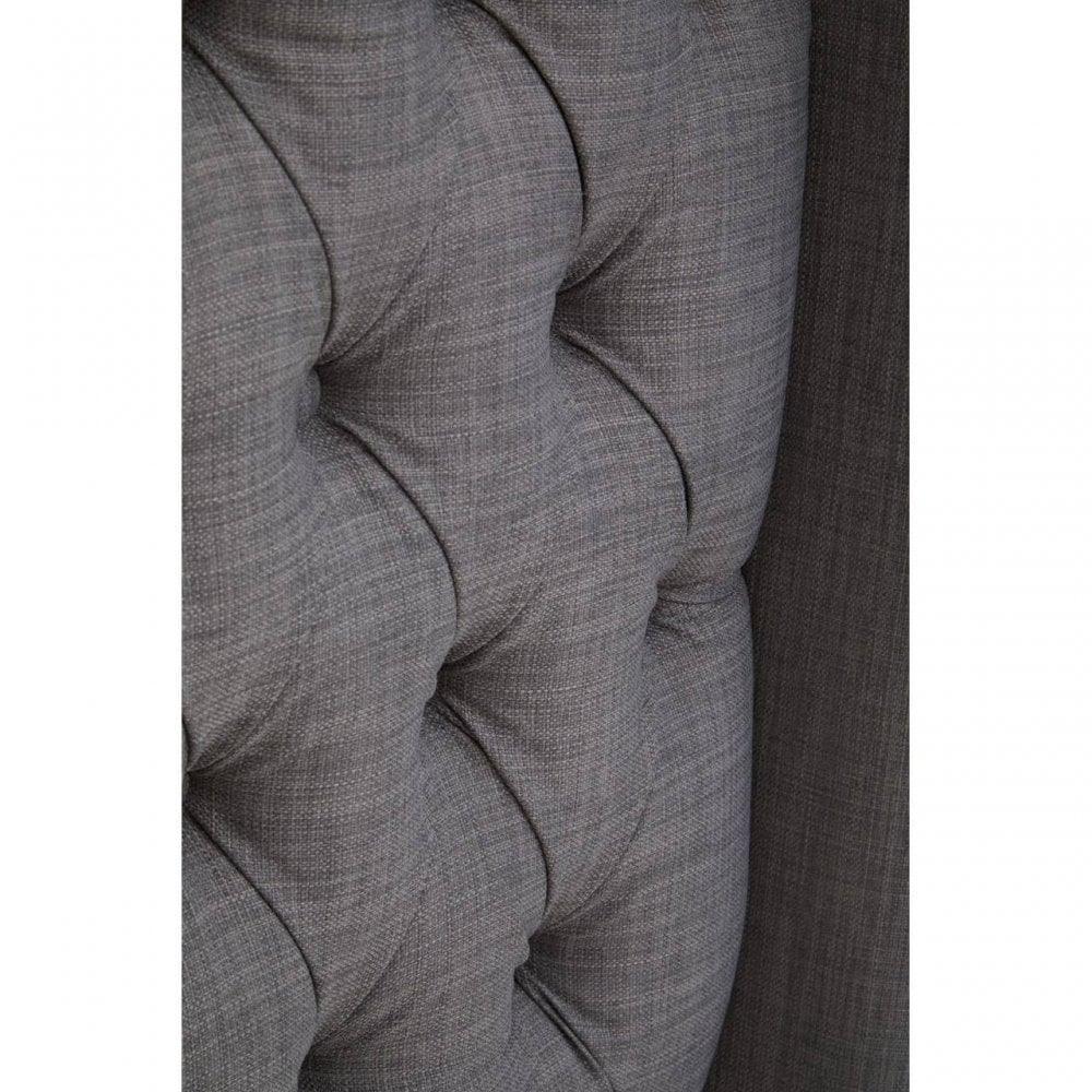 Close view of grey fabric sofa button-tufted upholstery texture