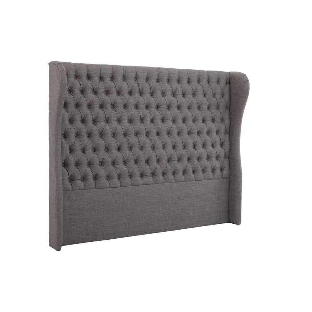 Grey upholstered bed headboard with deep button tufting and winged sides