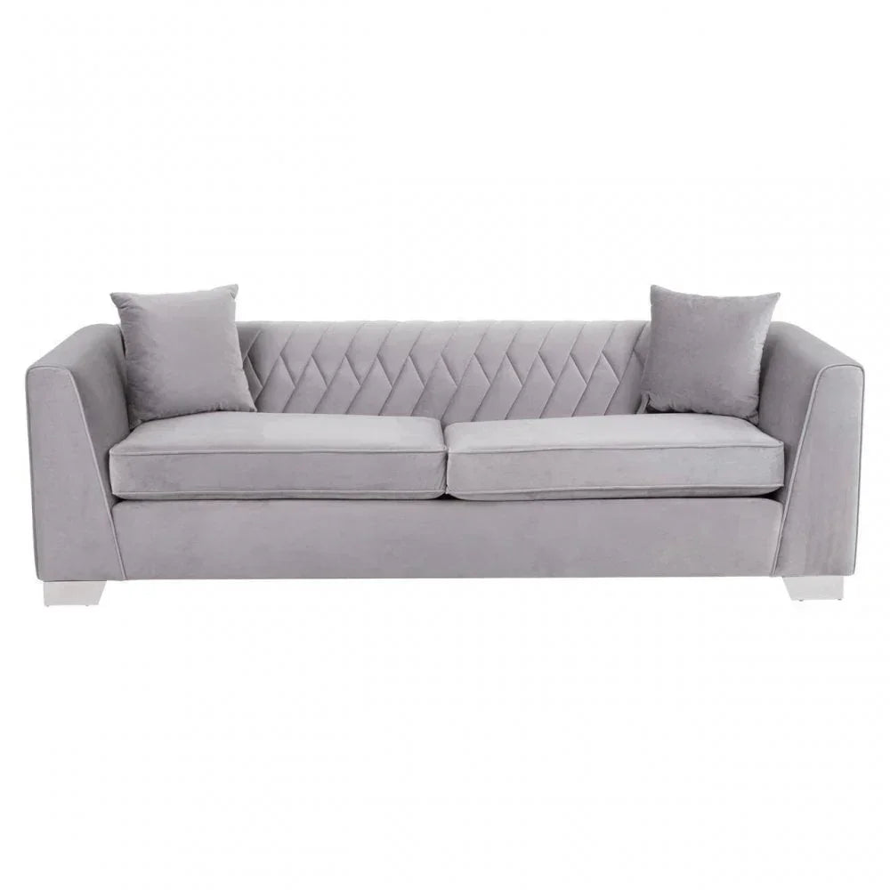 Grey velvet sofa with diamond-stitched backrest, two seat cushions, and matching pillows