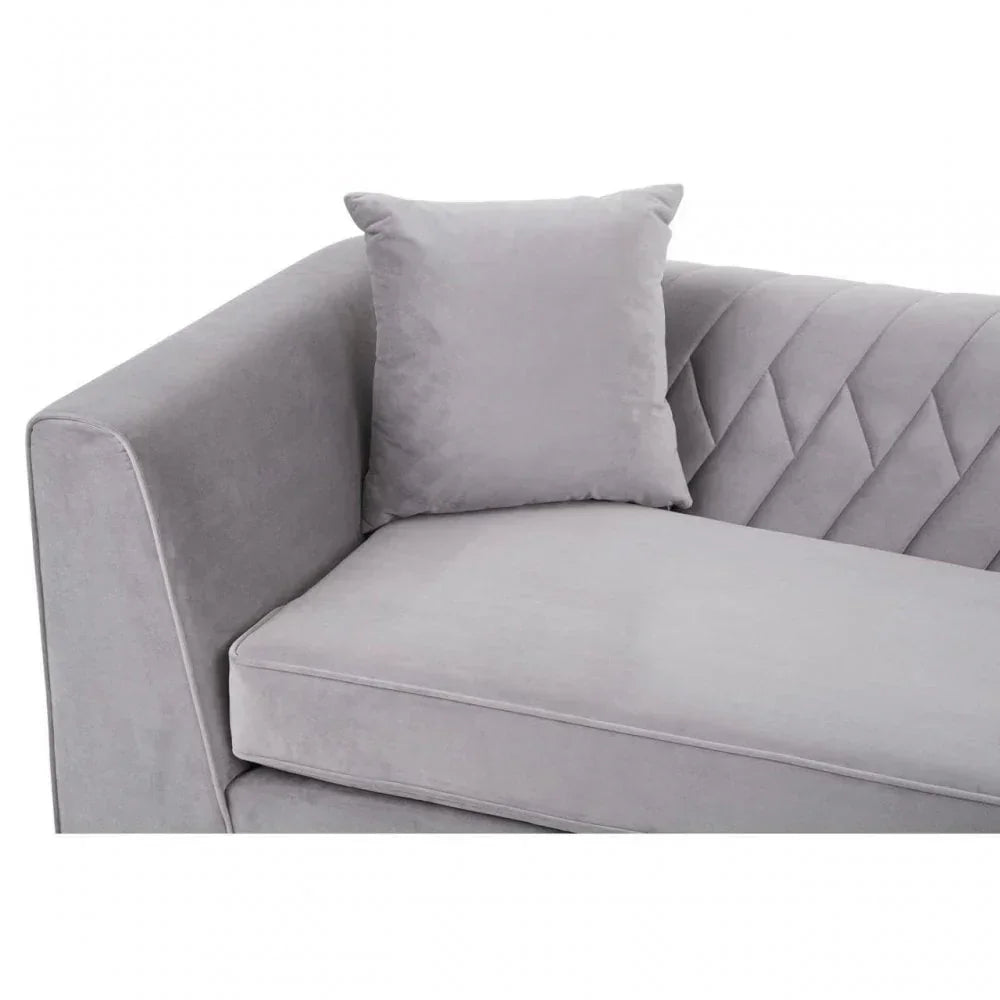 Grey velvet sofa with quilted backrest detail and matching cushion, corner view