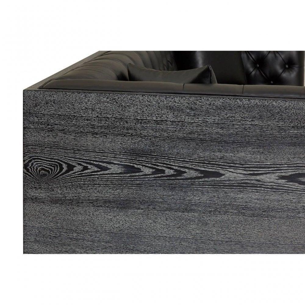 Close-up of black leather sofa with grey wood grain frame and tufted backrest