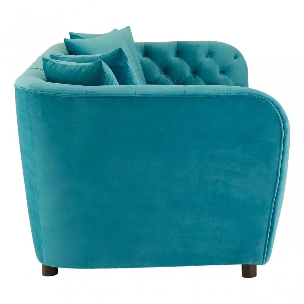 Side view of teal velvet sofa with button tufting and scatter cushions