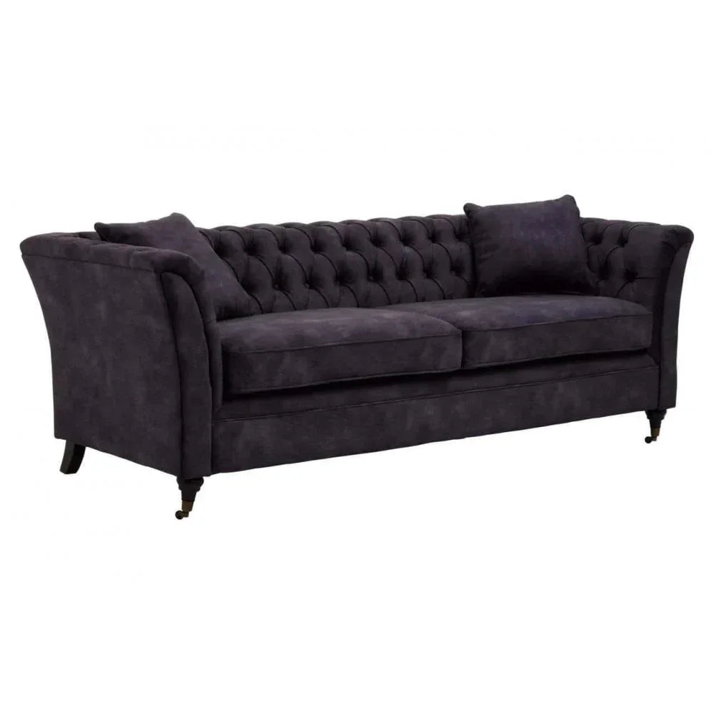 Dark grey chesterfield sofa with tufted back, two seat cushions and two matching pillows