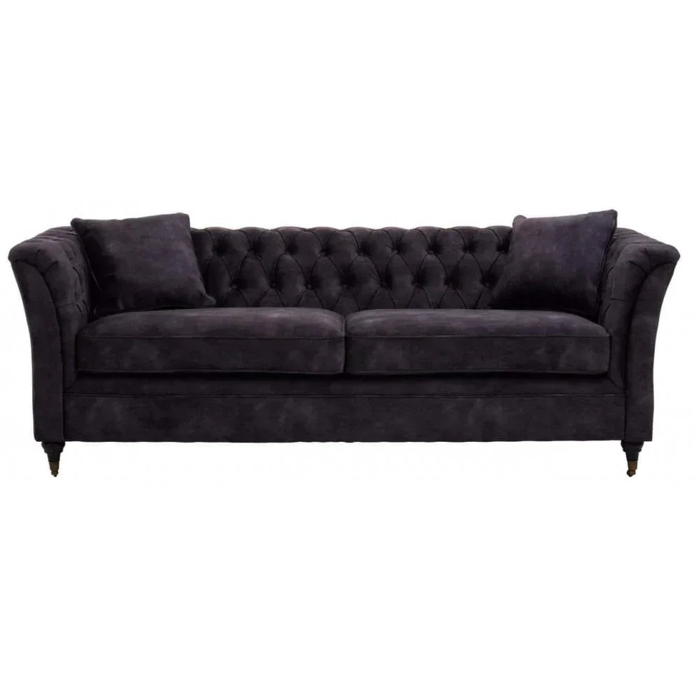 Black velvet chesterfield sofa with button-tufted back and two matching cushions