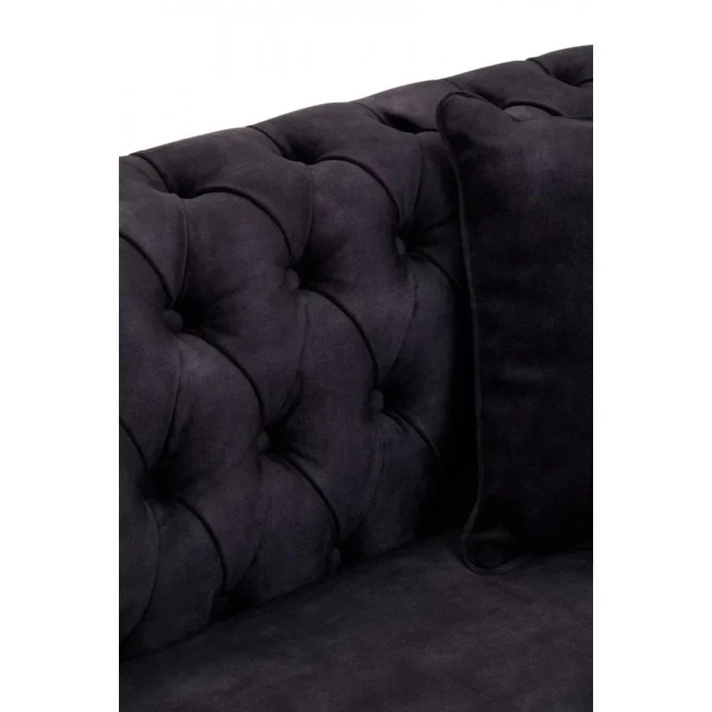 Close-up of black tufted sofa backrest with matching cushion