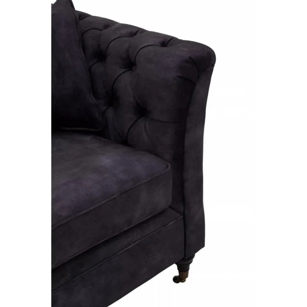 Dark fabric chesterfield sofa corner with button-tufted arm and turned wooden leg