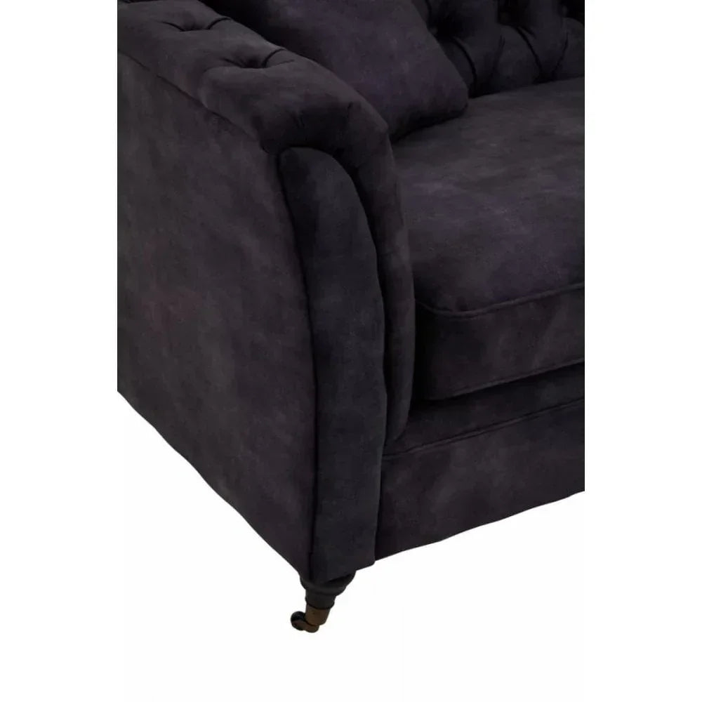 Dark fabric sofa armrest and cushion with tufted backrest and wooden leg detail