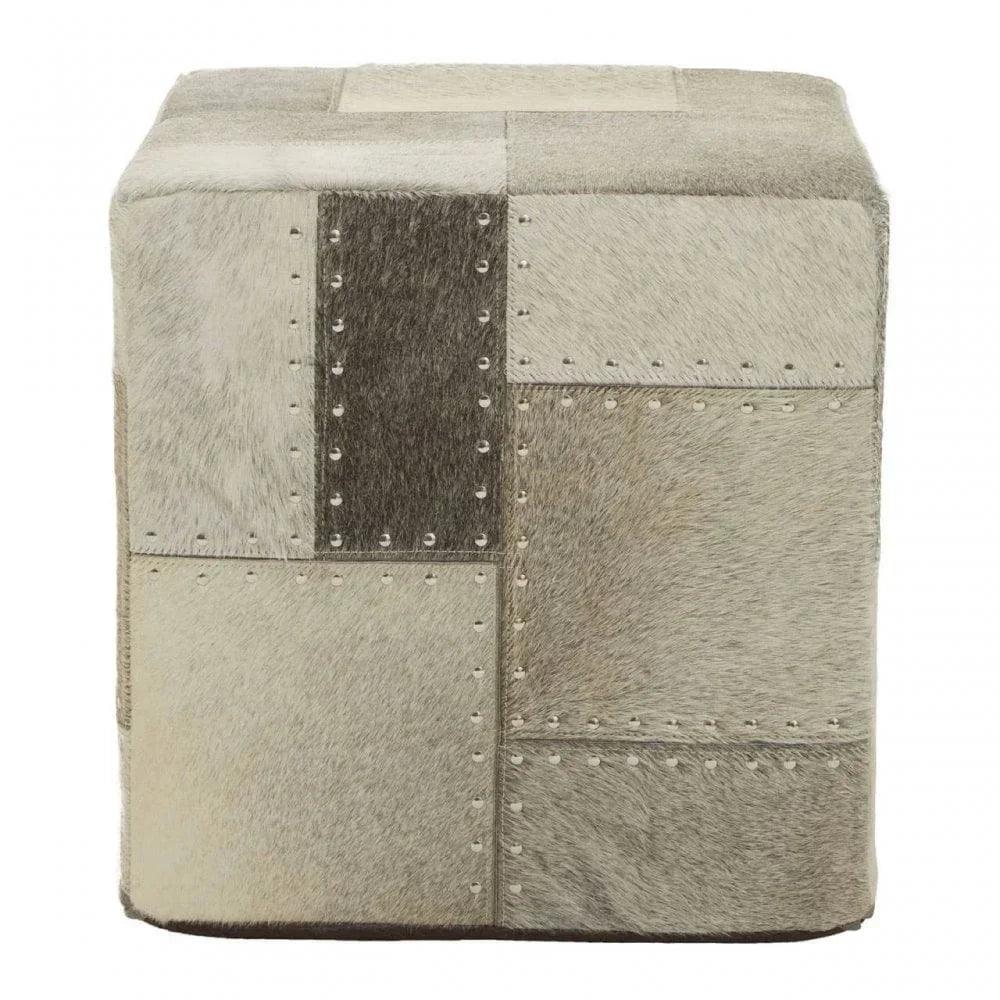 Patchwork cowhide pouffe with square shape and metal stud detailing