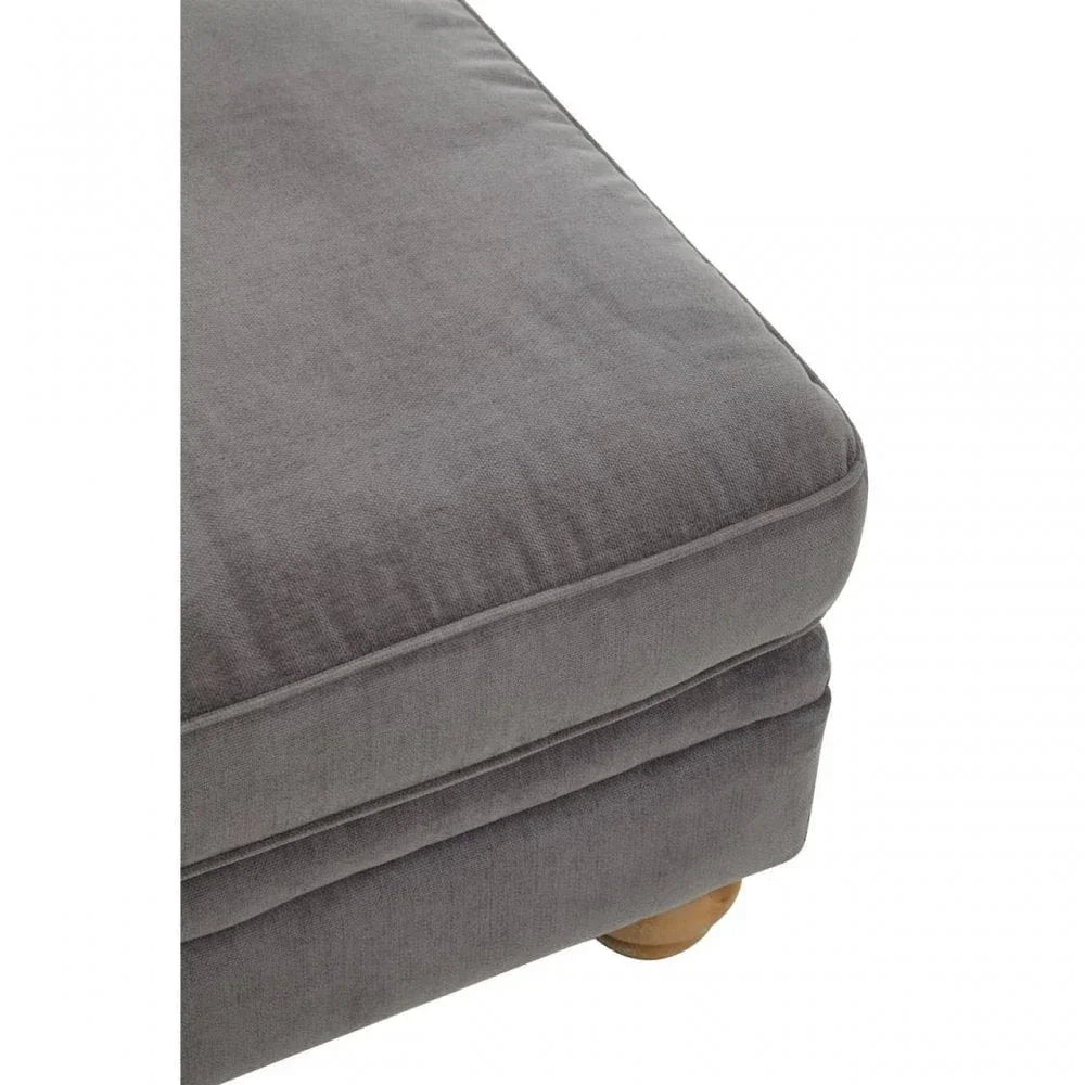 Close-up of grey fabric sofa cushion with visible seam and wooden leg