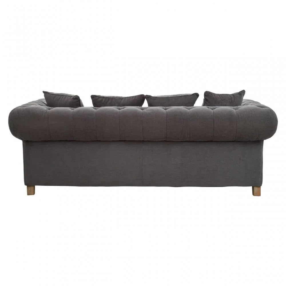 Dark grey chesterfield sofa rear view with tufted back, wooden legs, and matching cushions