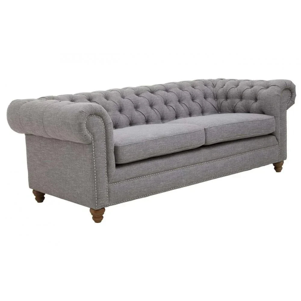 Grey fabric Chesterfield sofa with button-tufted back and oak legs, angled front view