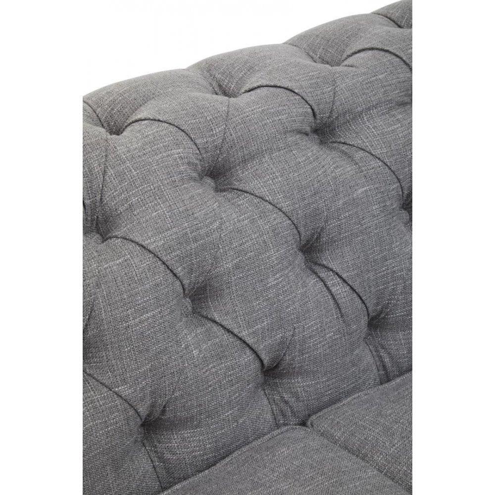 Close-up of grey fabric sofa backrest with deep button tufting