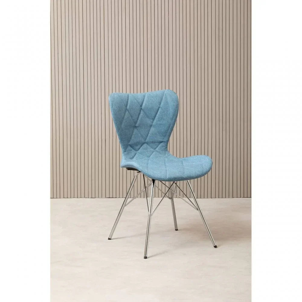 Blue fabric accent chair with quilted seat and chrome legs against a beige panel wall