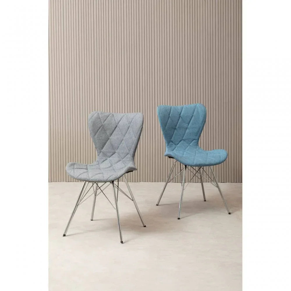Two quilted fabric dining chairs with metal legs, one grey and one blue, on beige floor