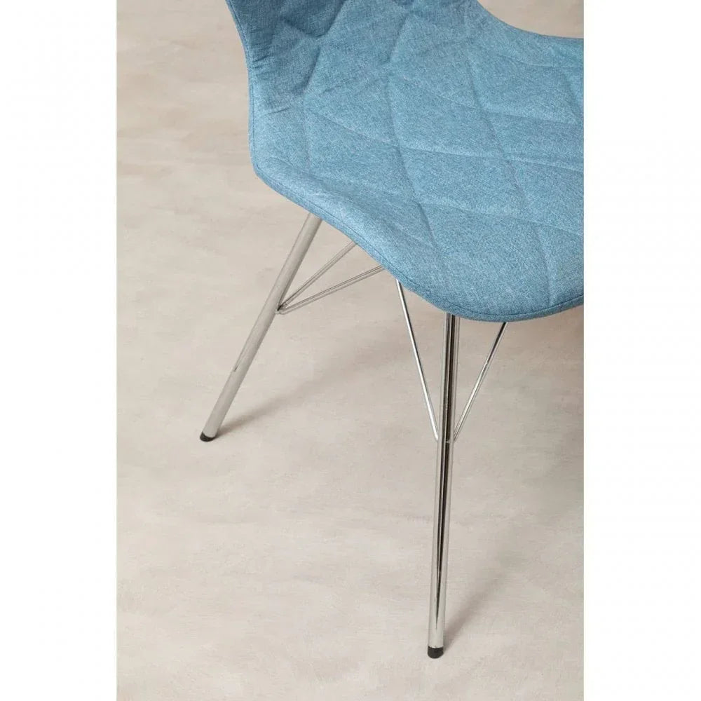 Blue fabric dining chair with chrome legs on beige floor, close-up view