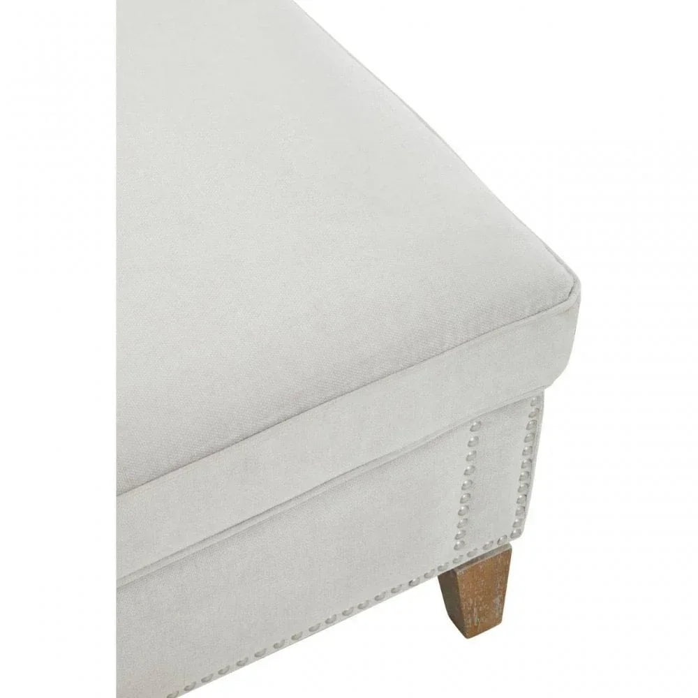 Light grey fabric ottoman corner with wooden leg and decorative stud detailing