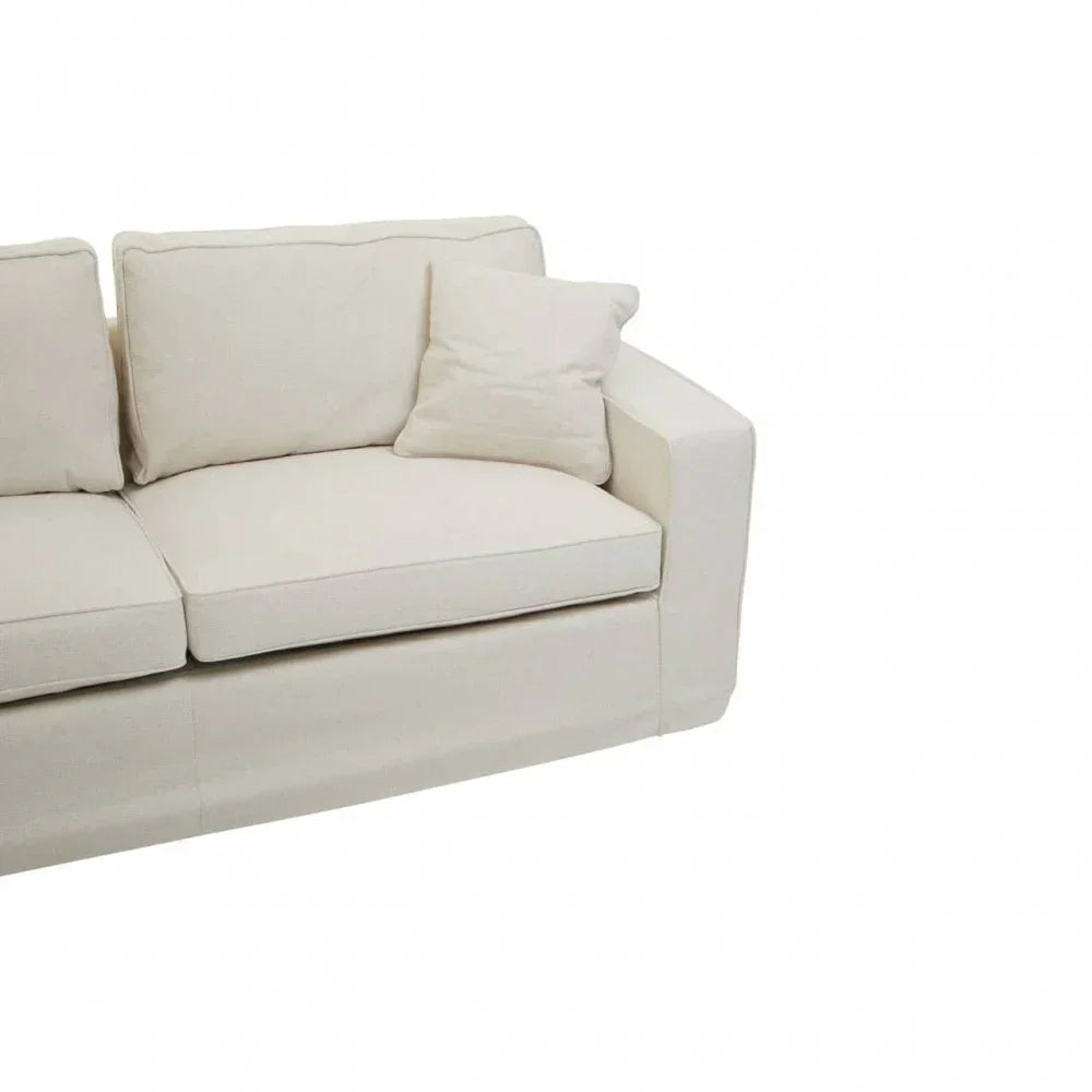 Cream fabric sofa with square arms and three back cushions, partial front angle view