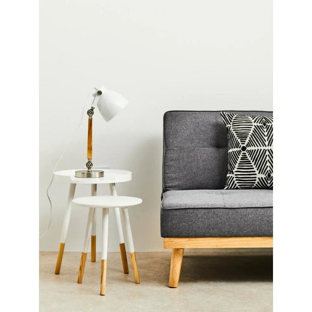 Grey sofa with wooden legs, geometric cushion, round white nesting tables and desk lamp