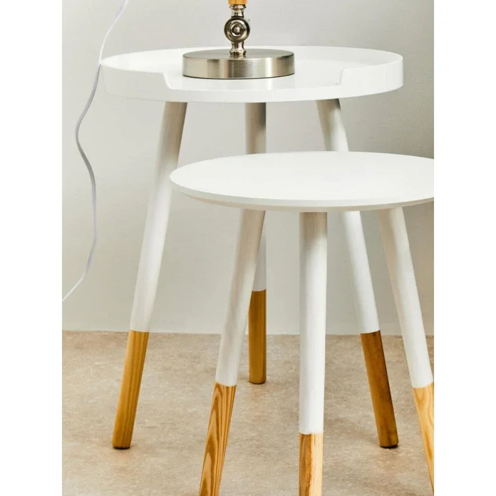White side tables with natural wood legs and a round tray top, lamp displayed on tabletop