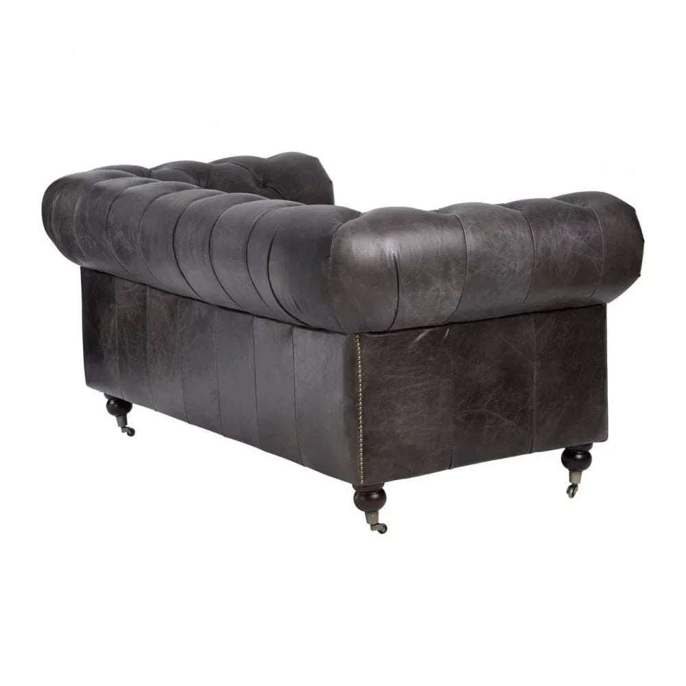 Dark brown leather chesterfield sofa rear view with button tufting and castor legs