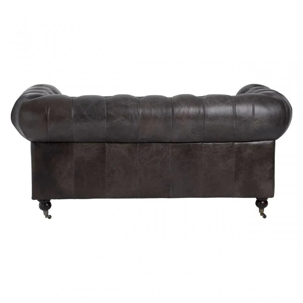 Brown leather Chesterfield sofa rear view with tufted back and rounded arms on castor legs
