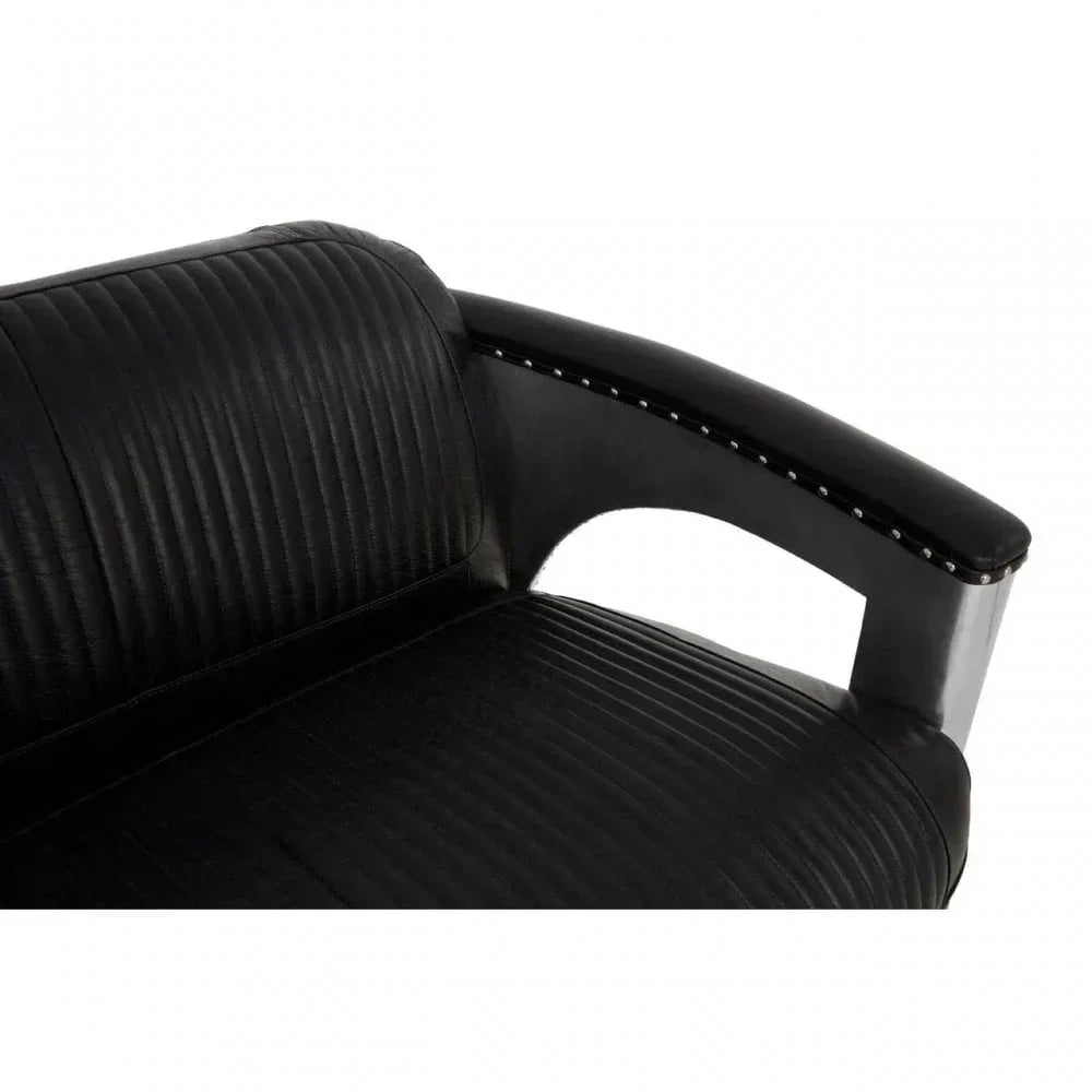 Close up of black leather sofa armrest with stitched detailing and chrome stud accents