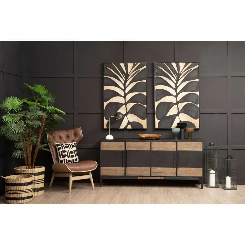 Modern sideboard with black and wood finish in styled living room with wall art and chair