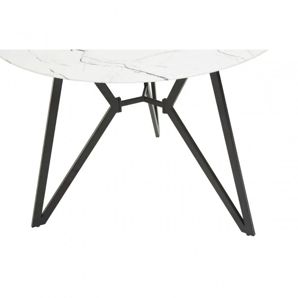 Round marble dining table with black metal angled legs, close-up of base and edge