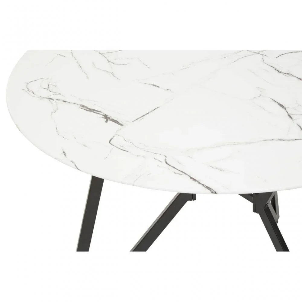 Round marble dining table with black metal legs, close-up of white veined tabletop