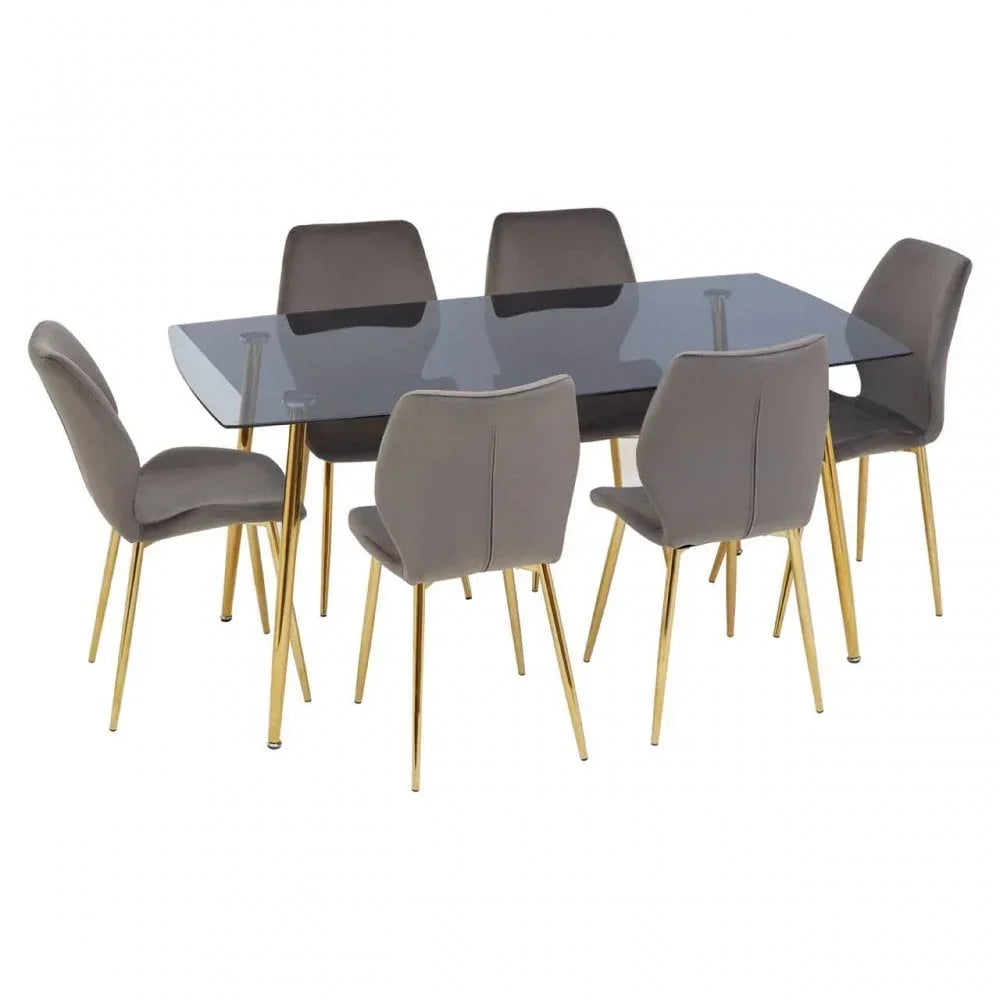 Glass dining table with six grey chairs and gold metal legs