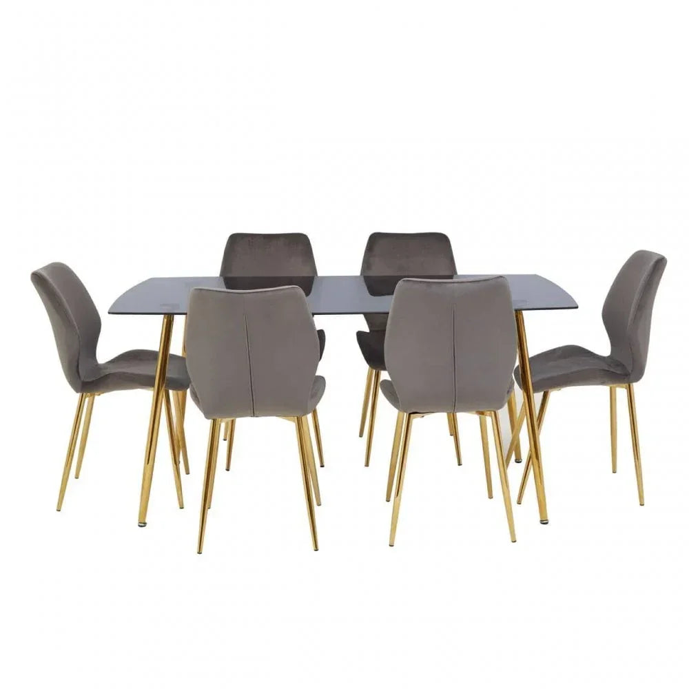 Modern dining set with grey velvet chairs and gold legs around a rectangular glass table