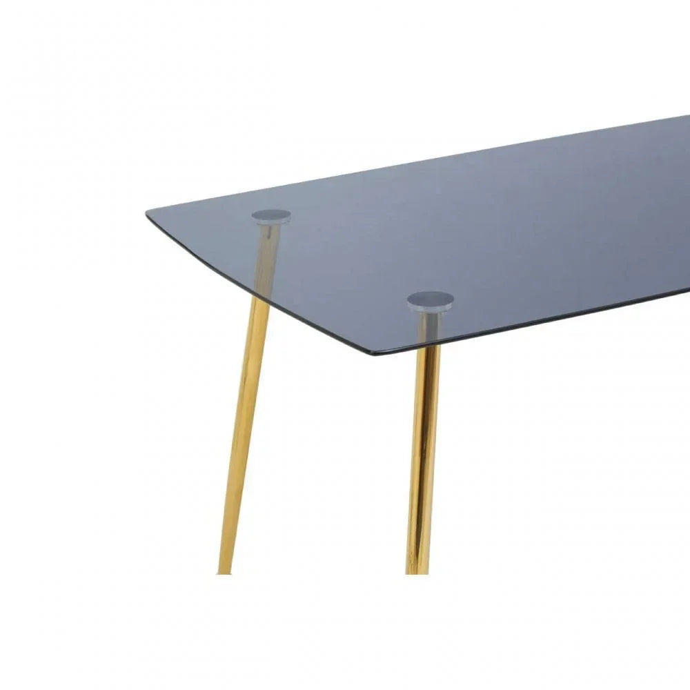 Glass dining table with gold metal legs, close-up of corner and sleek surface
