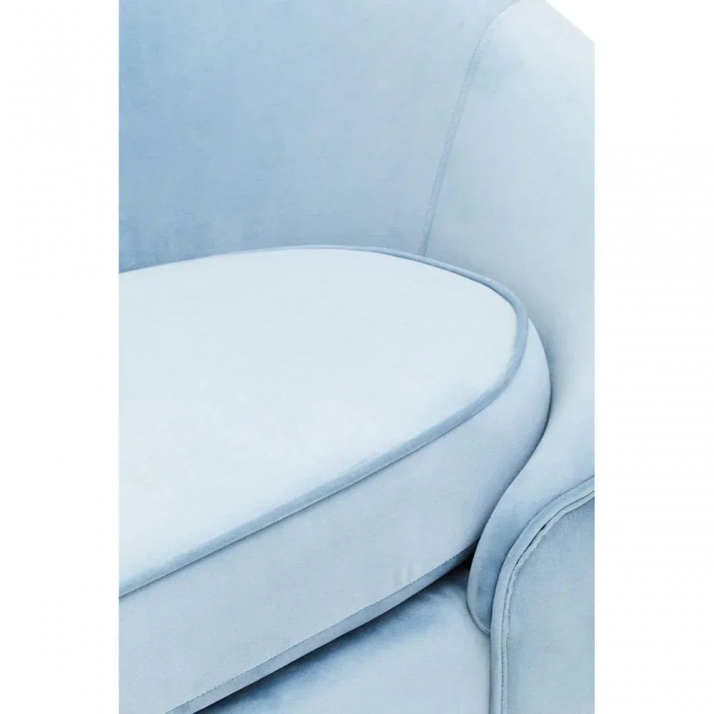 Close-up of blue velvet sofa seat cushion and curved armrest
