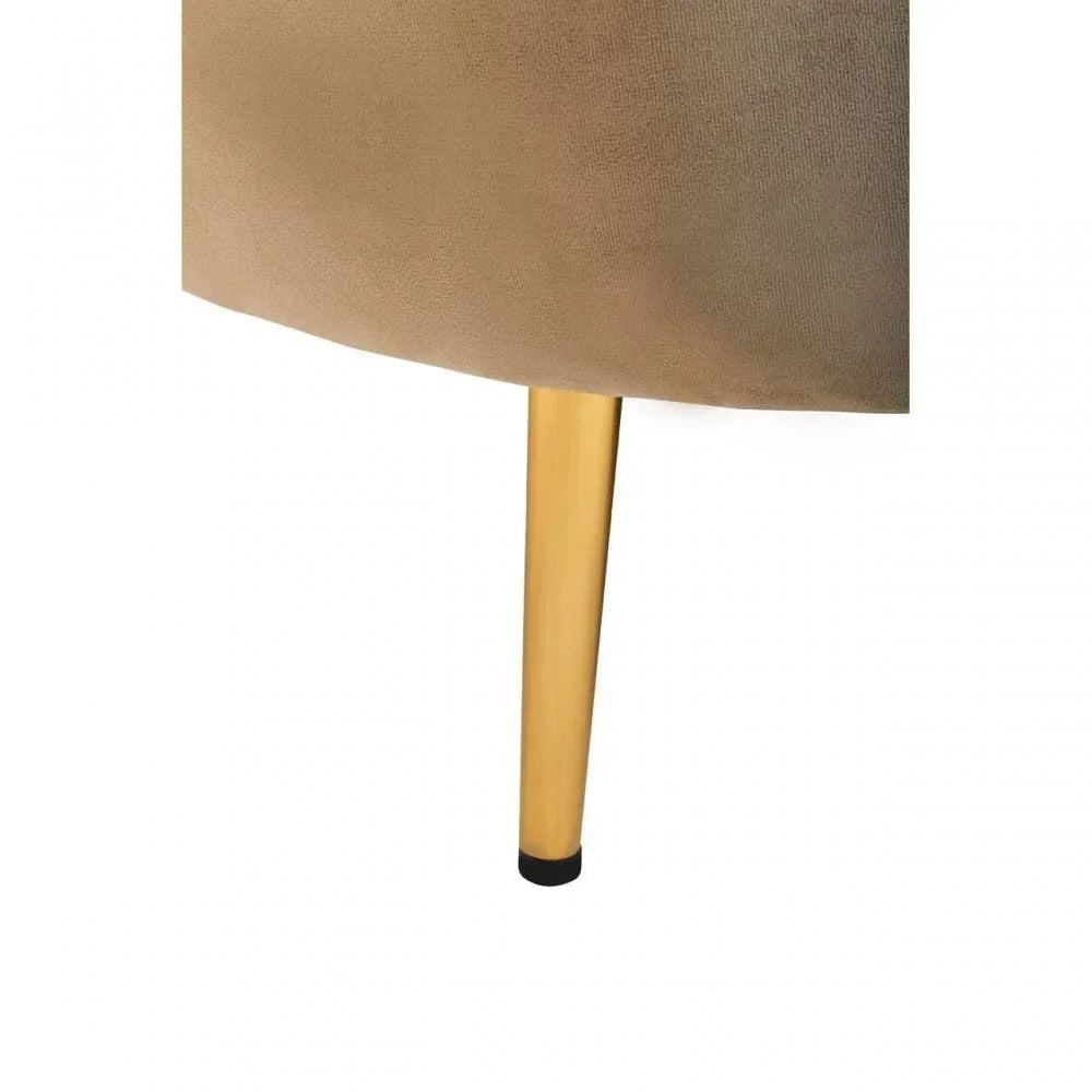 Gold metal chair leg with beige fabric upholstery close-up