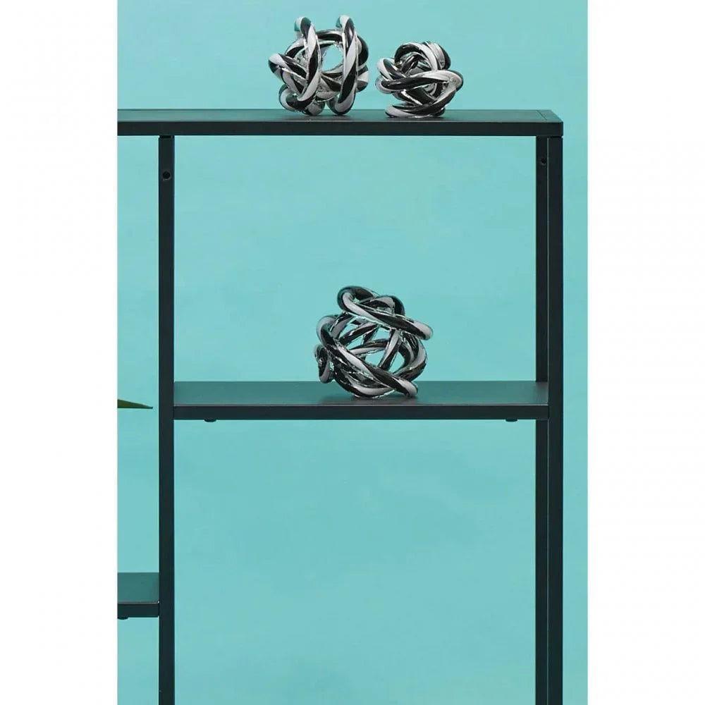 Black metal shelving with chrome knot decorative ornaments against blue background