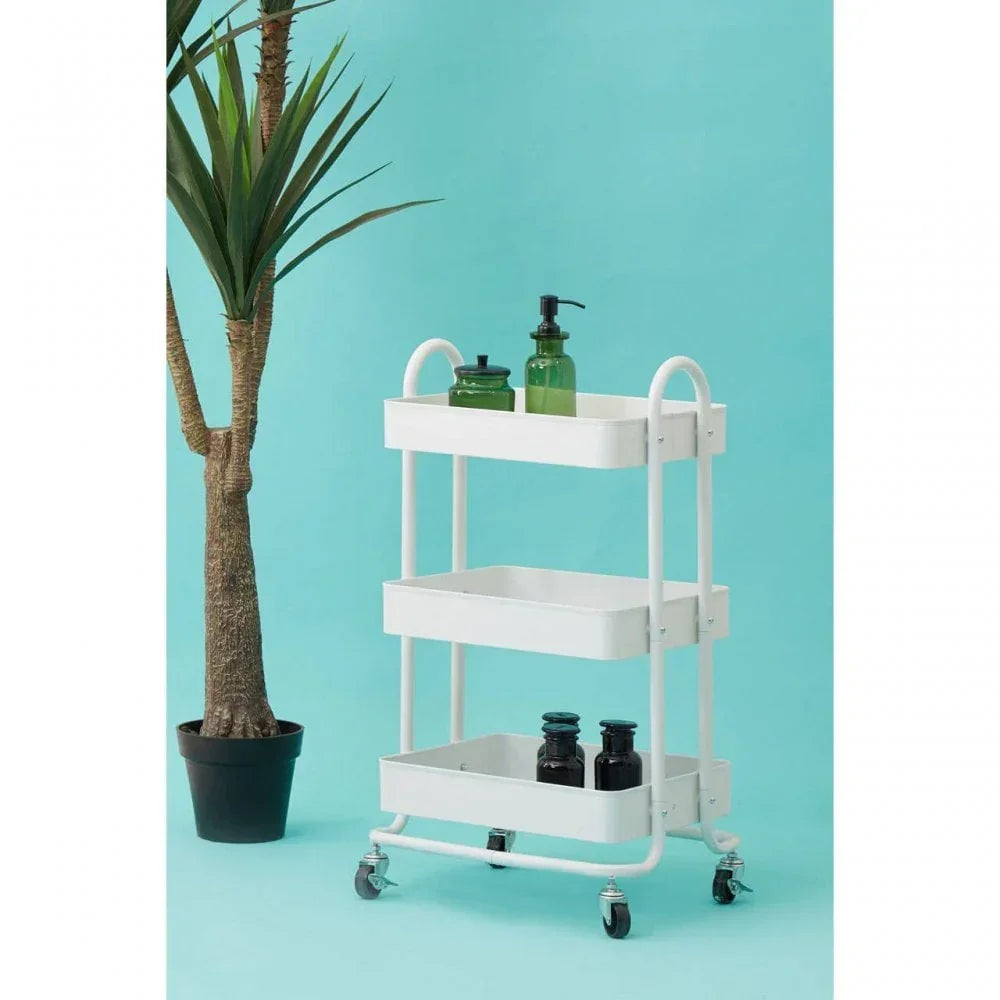 White three tier storage trolley with wheels beside potted plant on blue background