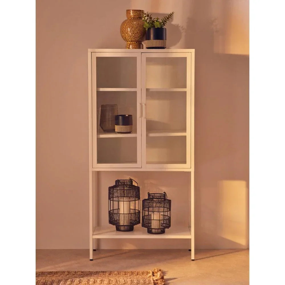 White display cabinet with glass doors, home decor items, and black lanterns on lower shelf