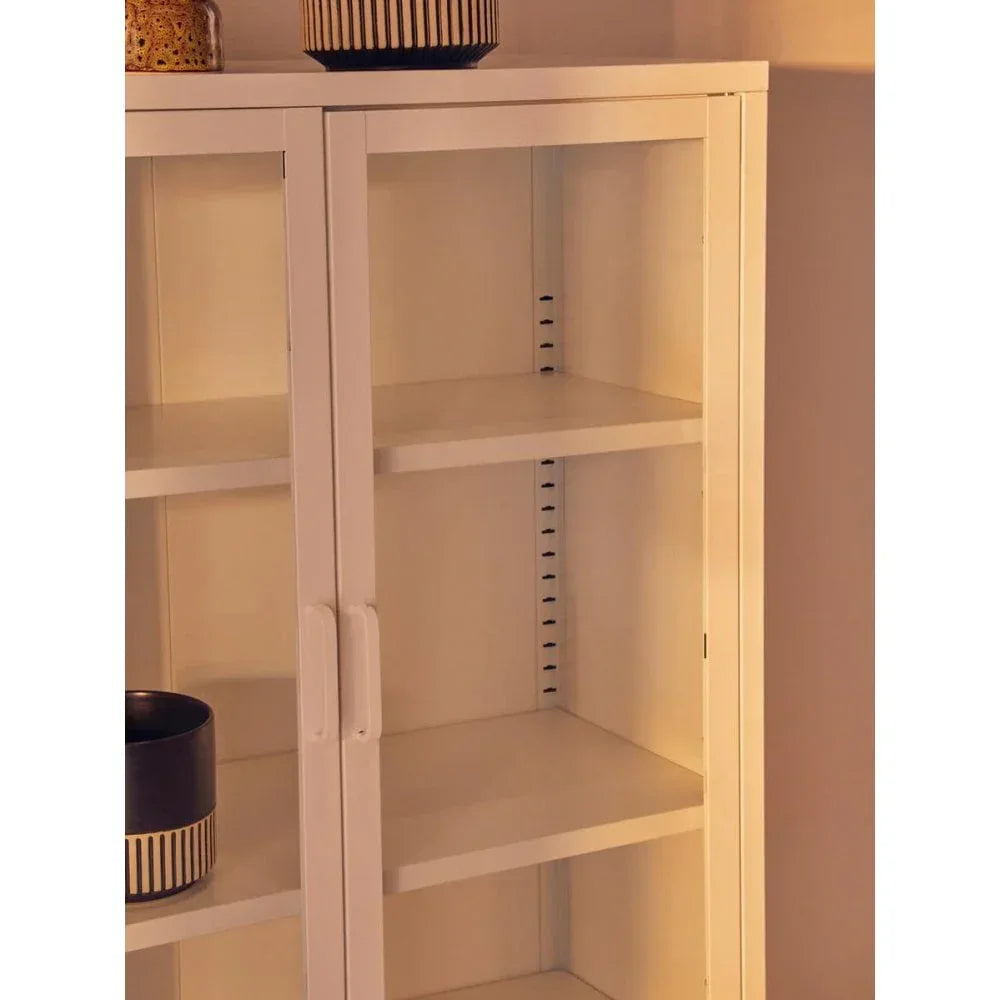 White shelving unit with glass doors and adjustable shelves, decorative pots on top