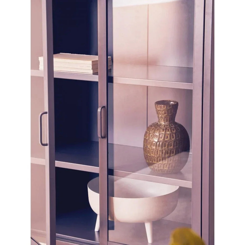Glass display cabinet with shelves holding a decorative vase, bowl, and stacked books