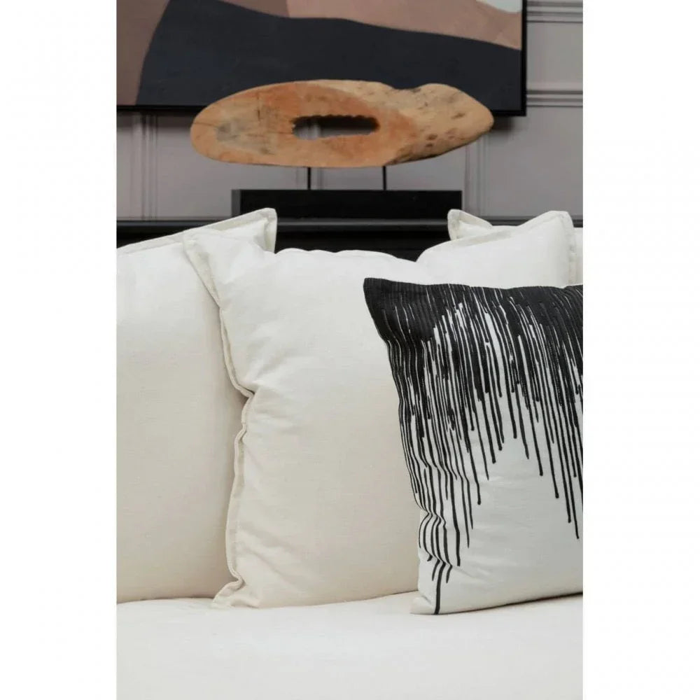 Cream sofa with plain and black abstract patterned cushions in a modern living room