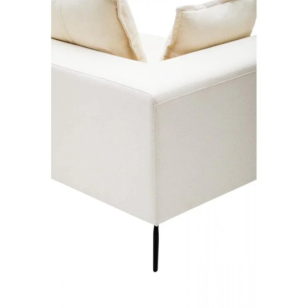 Cream fabric sofa corner with slim black metal leg and two matching cushions