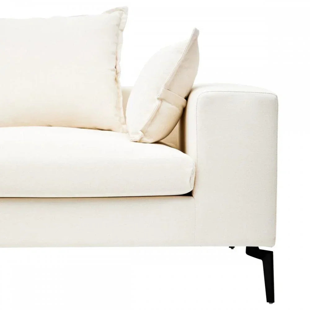 Cream fabric sofa corner with matching cushions and black metal legs